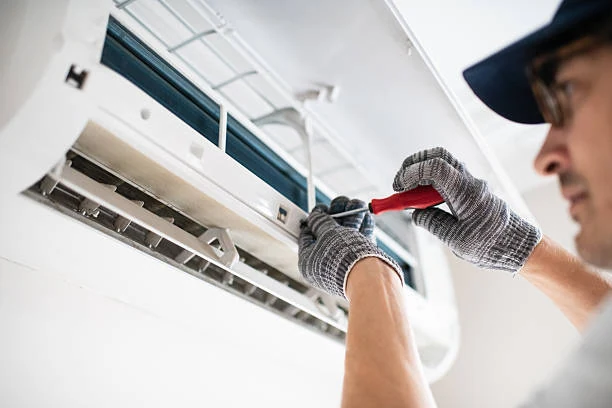 Technician working on an open wall-mounted air conditioning unit